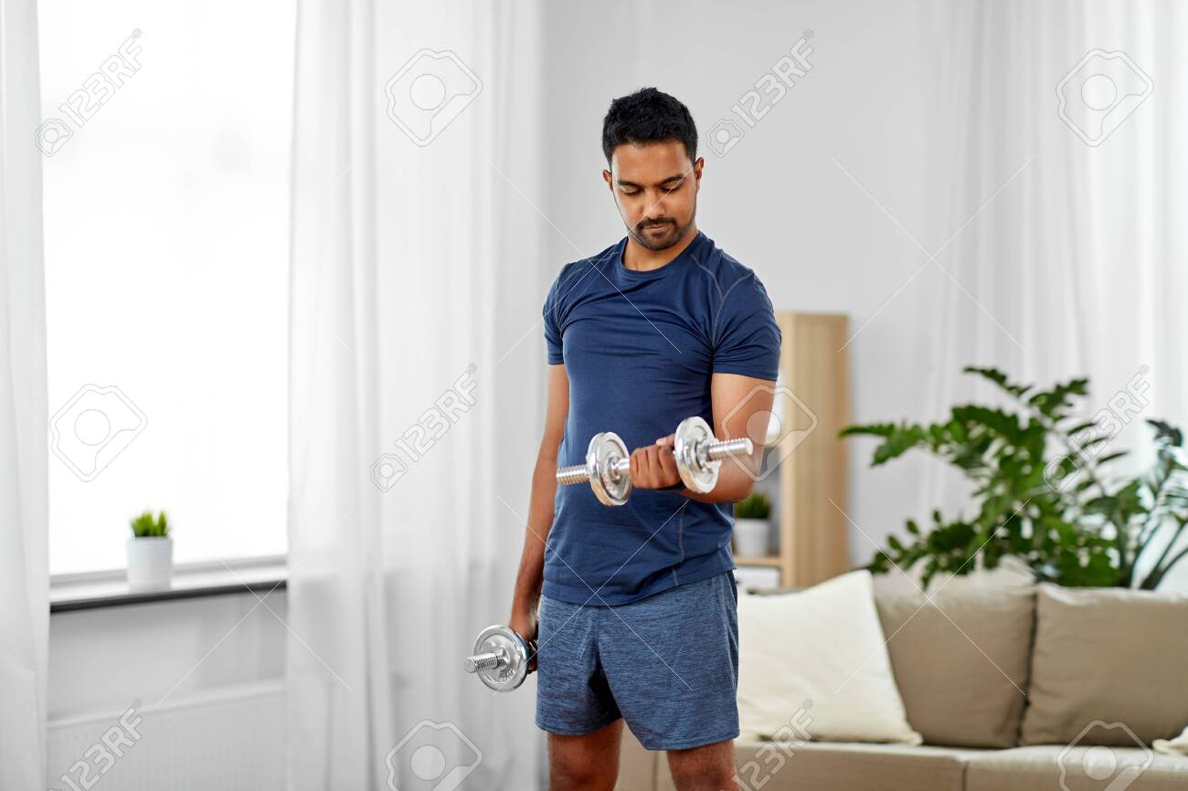 indian man exercising with dumbbells at home - 124629786 indian man exercising with dumbbells at home - 124629786