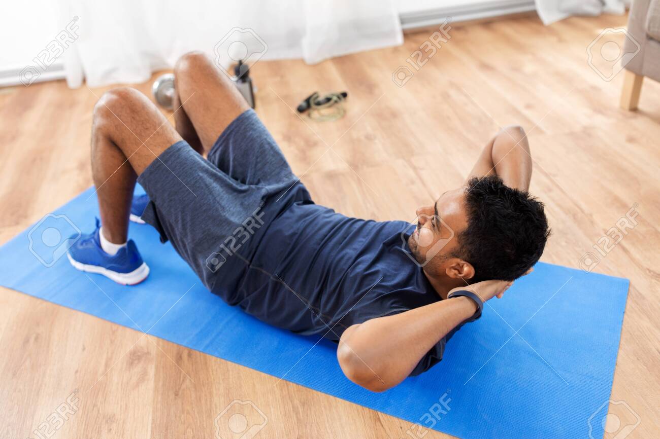 Indian man making abdominal exercises at home - 125188558 Indian man making abdominal exercises at home - 125188558