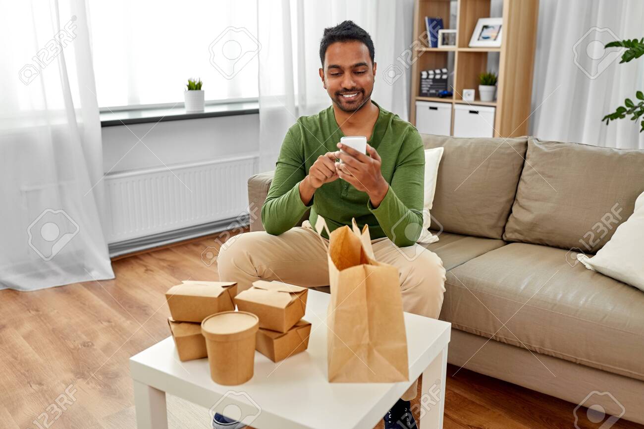 indian man checking takeaway food order at home - 126481425 indian man checking takeaway food order at home - 126481425