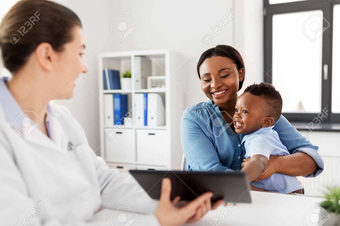 Mother with baby and doctor with tablet at clinic - 126774843 Mother with baby and doctor with tablet at clinic - 126774843