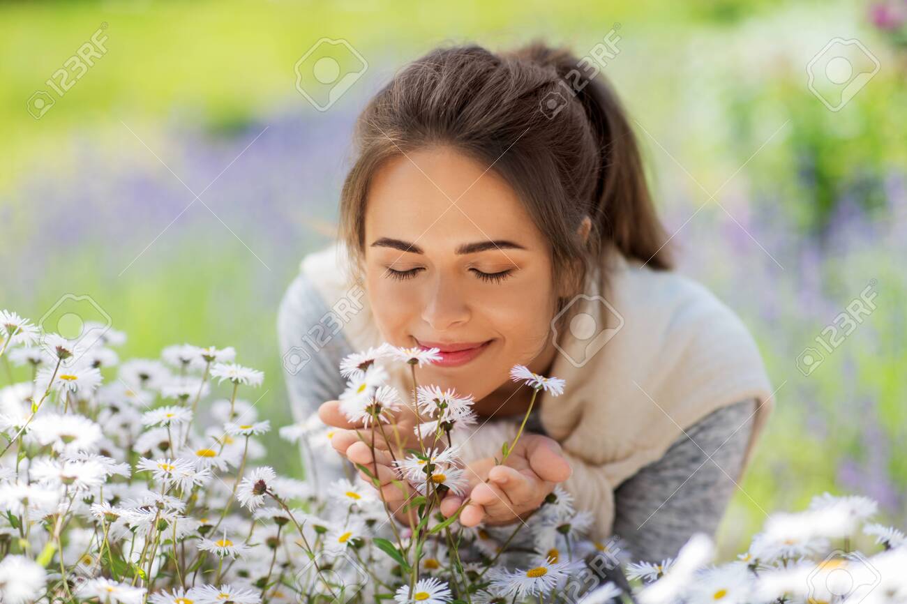 close up of woman smelling chamomile flowers - 128089991 close up of woman smelling chamomile flowers - 128089991