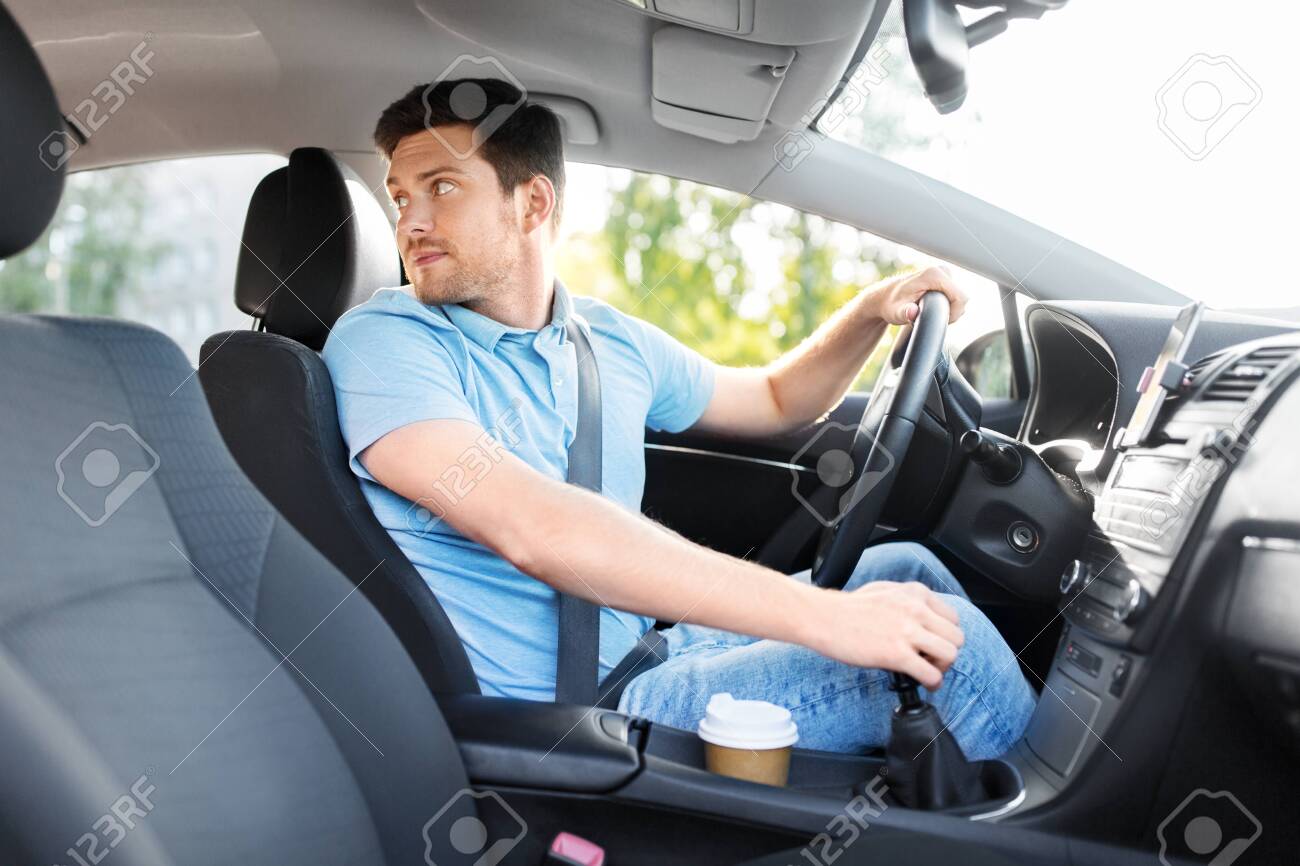 transport, vehicle and driving concept - man or car driver looking back - 130121139 transport, vehicle and driving concept - man or car driver looking back - 130121139