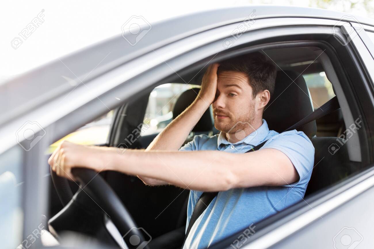 transport, vehicle and driving concept - tired sleepy man or car driver rubbing eyes - 130121148 transport, vehicle and driving concept - tired sleepy man or car driver rubbing eyes - 130121148