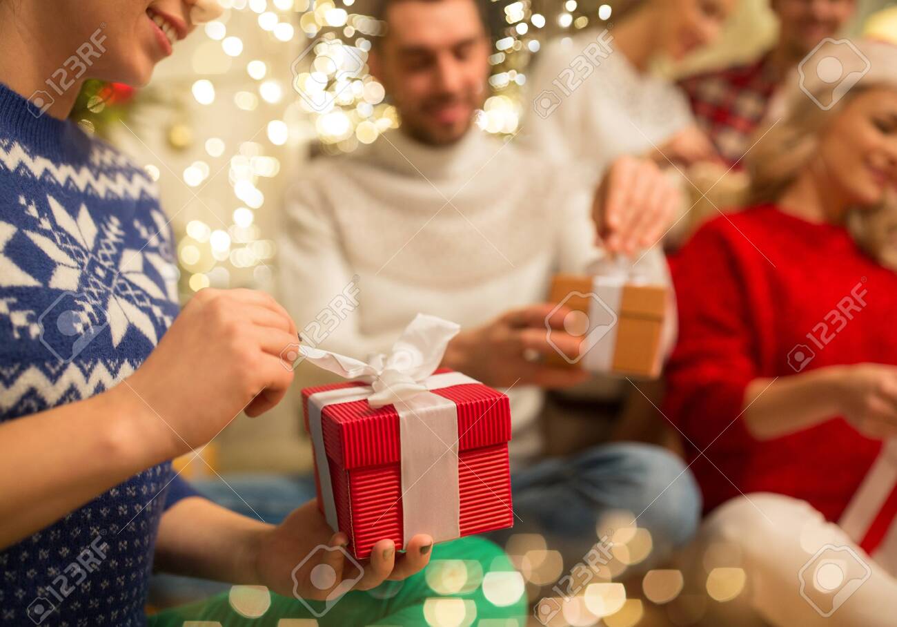 close up of friends opening christmas gifts - 130493460 close up of friends opening christmas gifts - 130493460