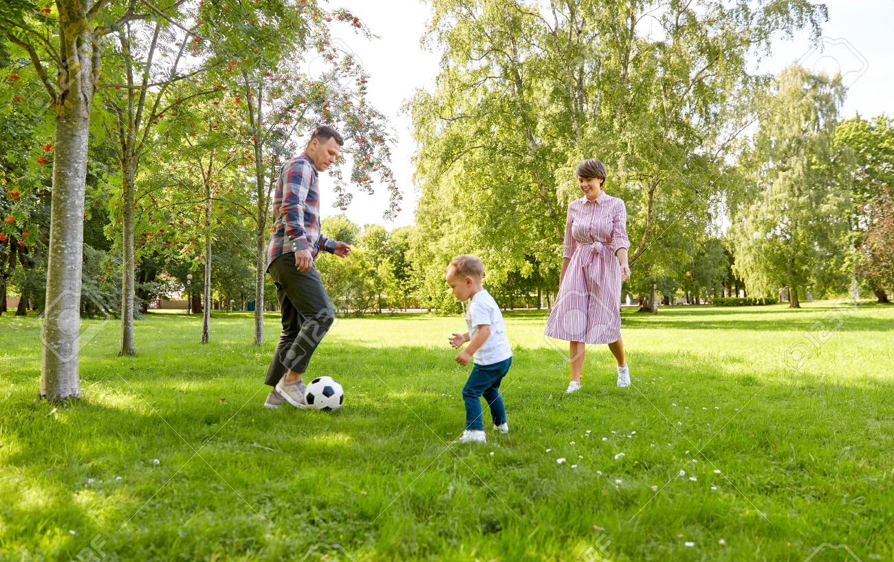 happy family playing soccer at summer park - 130587279 happy family playing soccer at summer park - 130587279