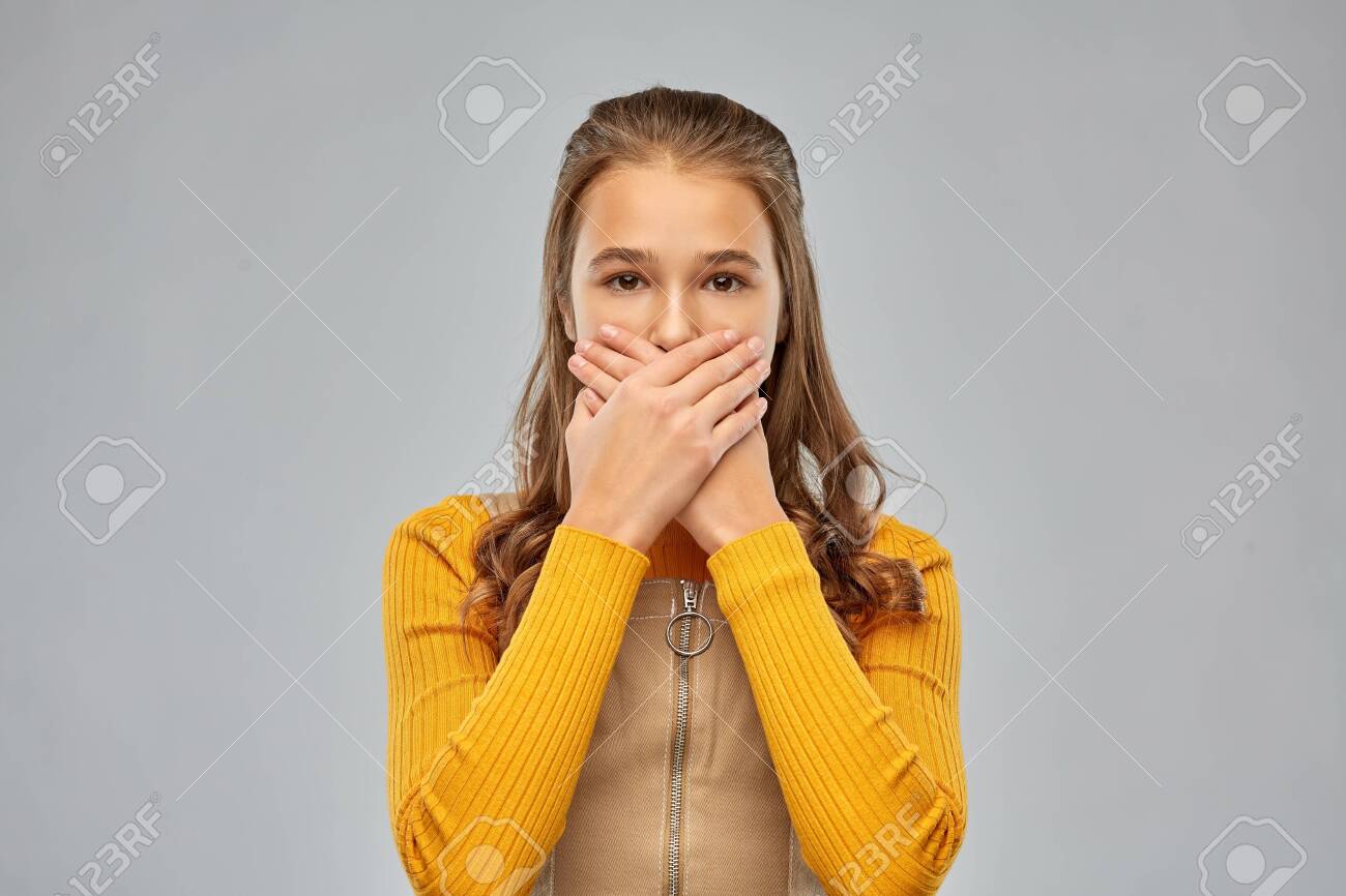 scared teenage girl closing her mouth by hands - 134284818 scared teenage girl closing her mouth by hands - 134284818