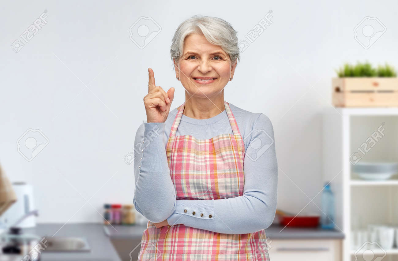 smiling senior woman pointing finger up at kitchen - 169910293 smiling senior woman pointing finger up at kitchen - 169910293