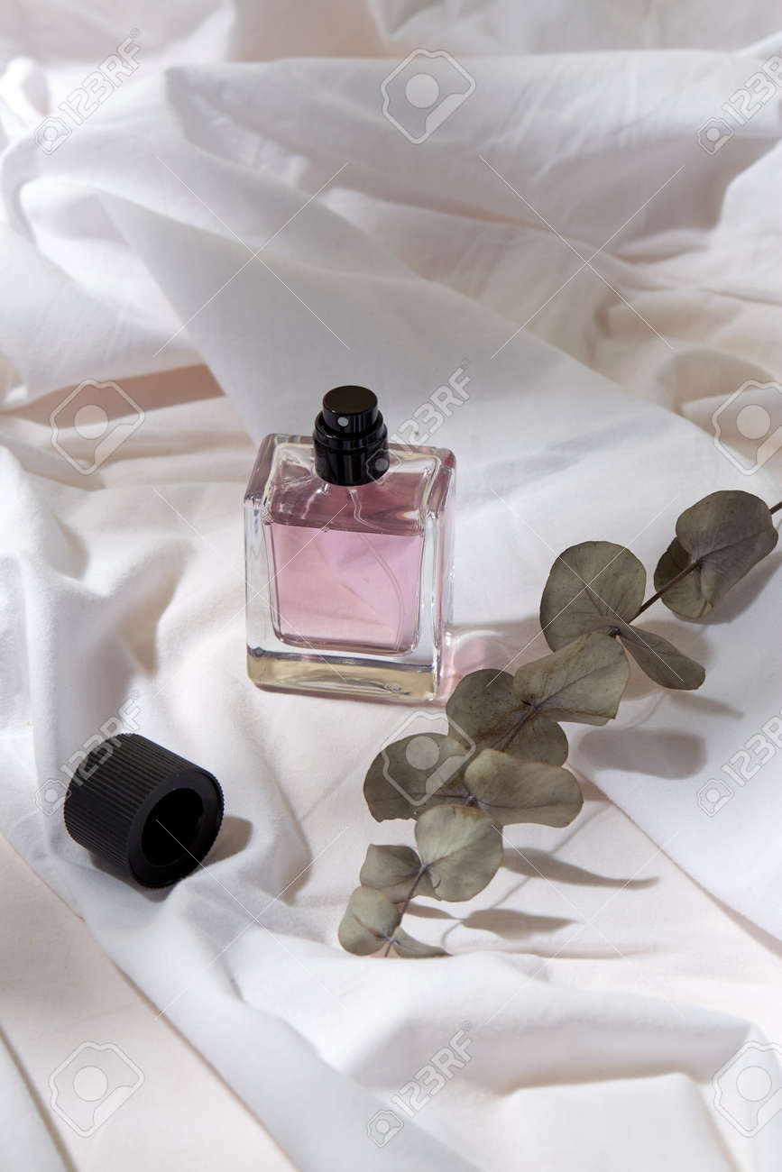 bottle of perfume and on white sheet - 169966593 bottle of perfume and on white sheet - 169966593