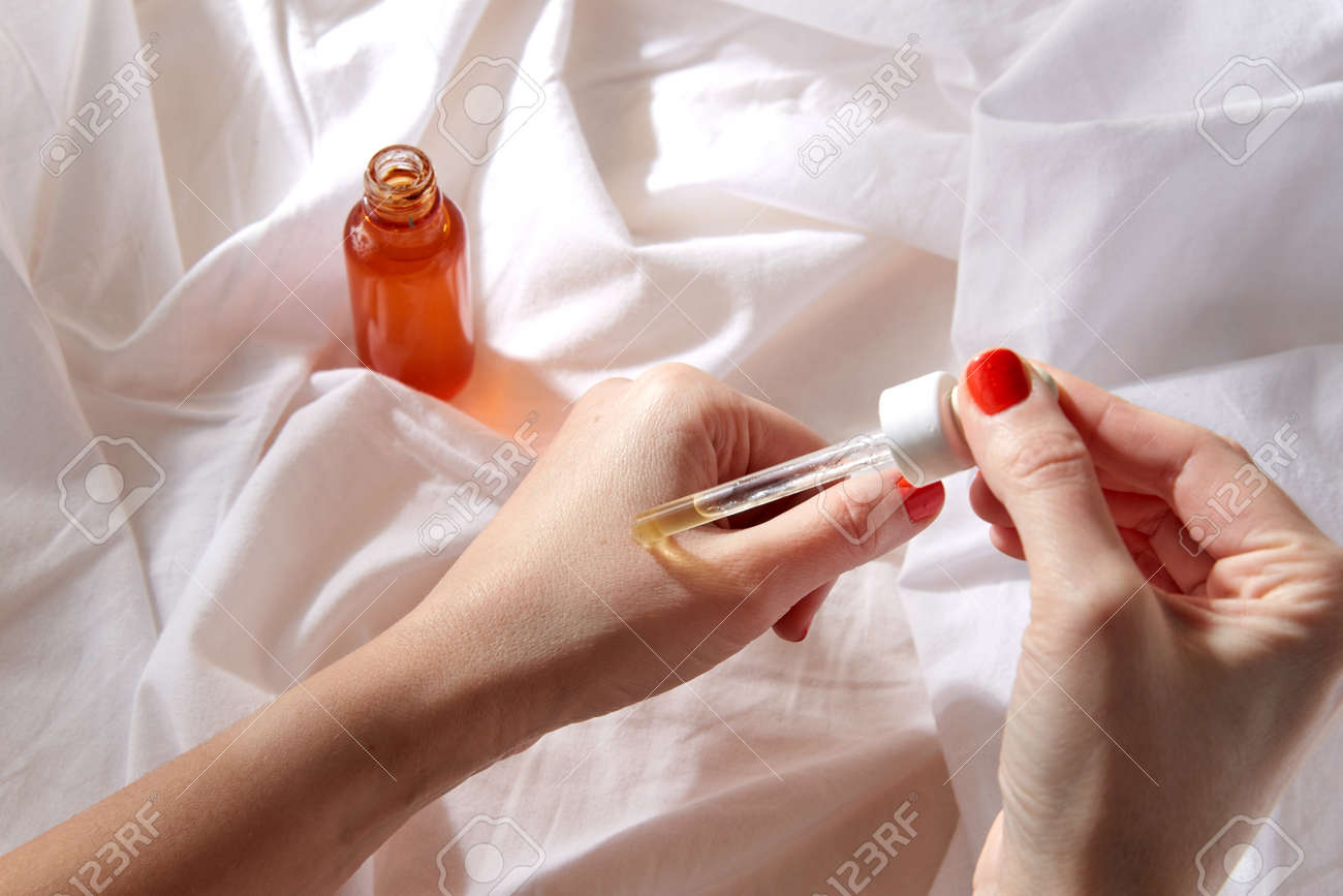 female hands with dropper applying serum to skin - 169966361 female hands with dropper applying serum to skin - 169966361