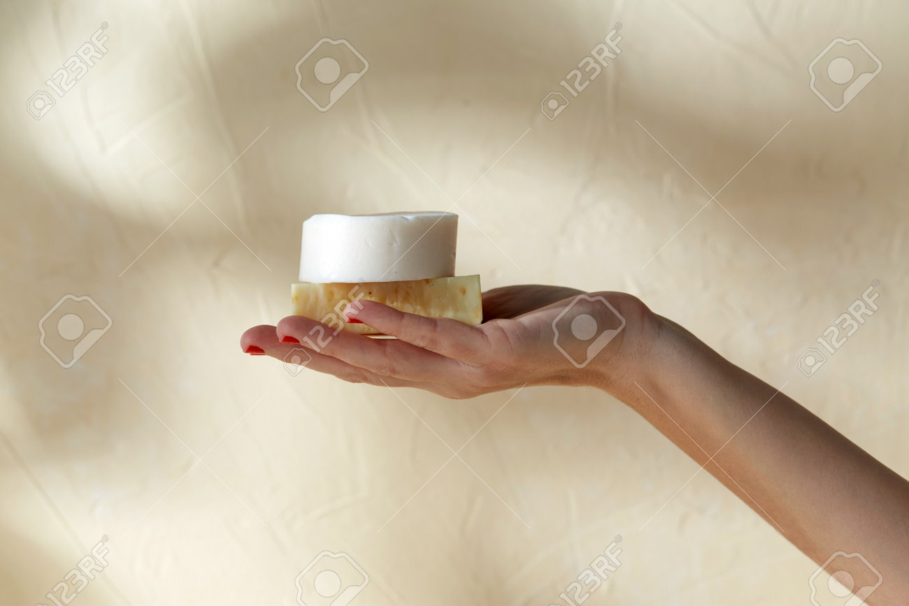 hand holding bar of craft soap on beige background - 169966478 hand holding bar of craft soap on beige background - 169966478