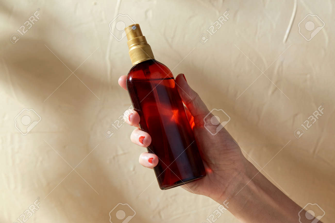 close up of hand with bottle of sunscreen oil - 169966273 close up of hand with bottle of sunscreen oil - 169966273