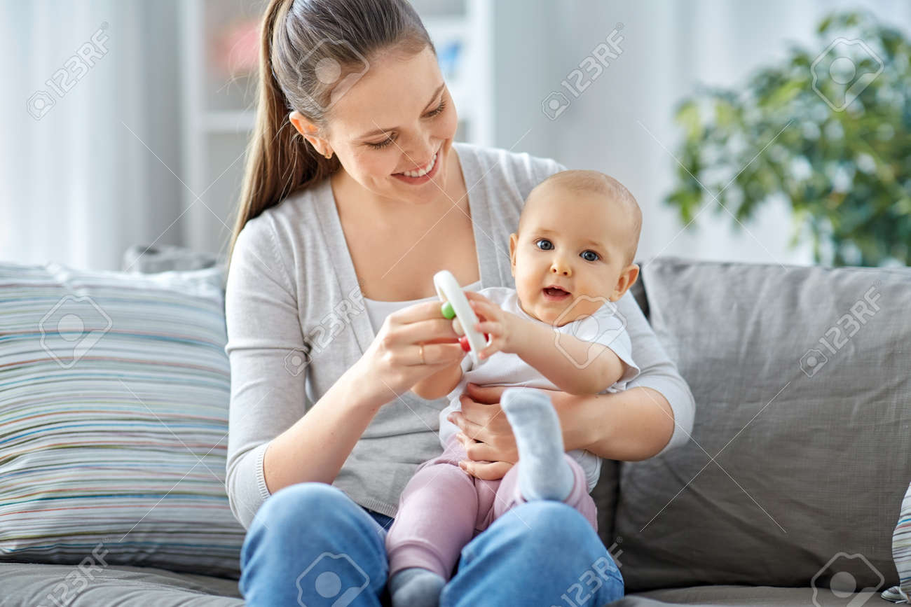 mother and little baby playing with rattle at home - 169965997 mother and little baby playing with rattle at home - 169965997