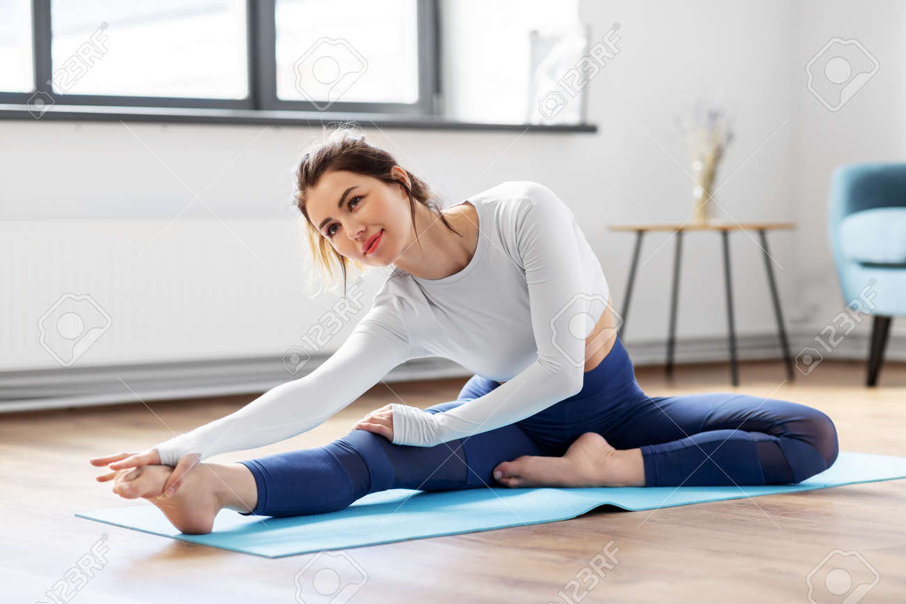 young woman doing yoga exercise at home - 169966514 young woman doing yoga exercise at home - 169966514