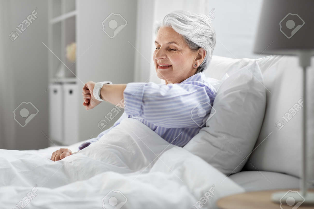 happy senior woman sitting in bed at home bedroom - 169967072 happy senior woman sitting in bed at home bedroom - 169967072