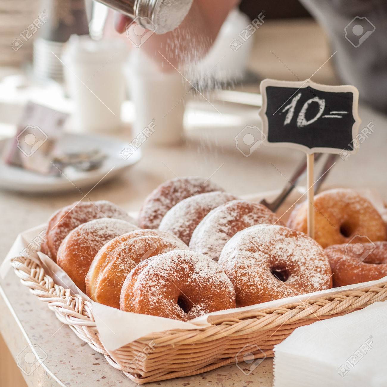 doughnut store counter donuts with icing sugar in a display stock