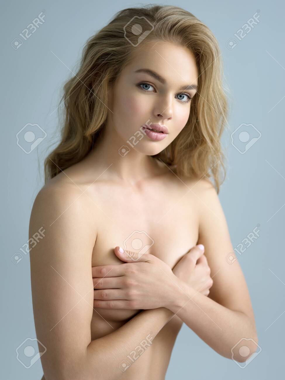 Beautiful Naked Girl Covers The Naked Breast. Gorgeous Woman With Nude  Body. Nice Portrait Of A Blonda Girl With Long Curly Hair. Фотография,  картинки, изображения и сток-фотография без роялти. Image 107933521