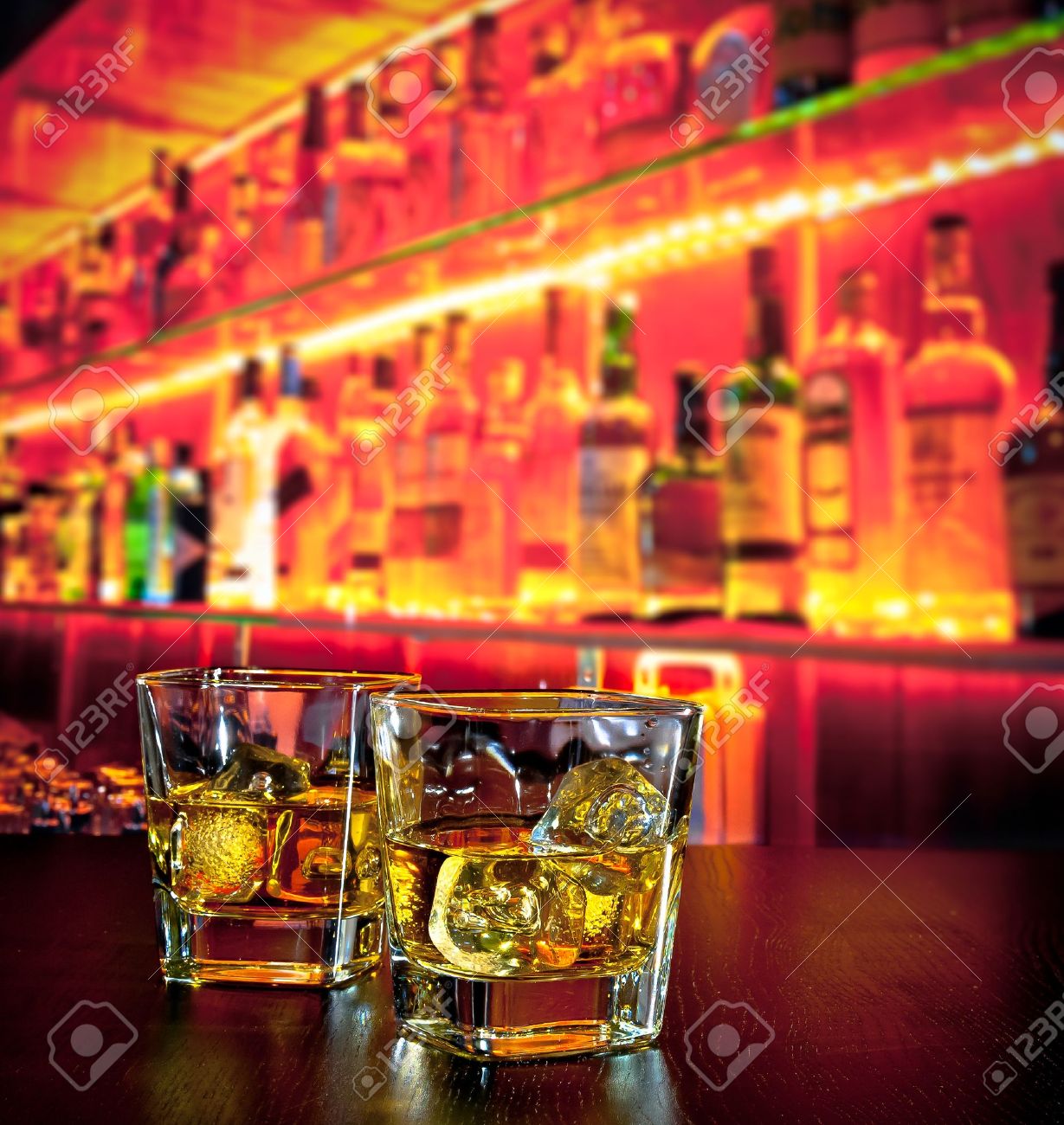 glasses of whiskey with ice on bar table near whiskey bottle on warm atmosphere lounge bar concept - 31406036 glasses of whiskey with ice on bar table near whiskey bottle on warm atmosphere lounge bar concept - 31406036