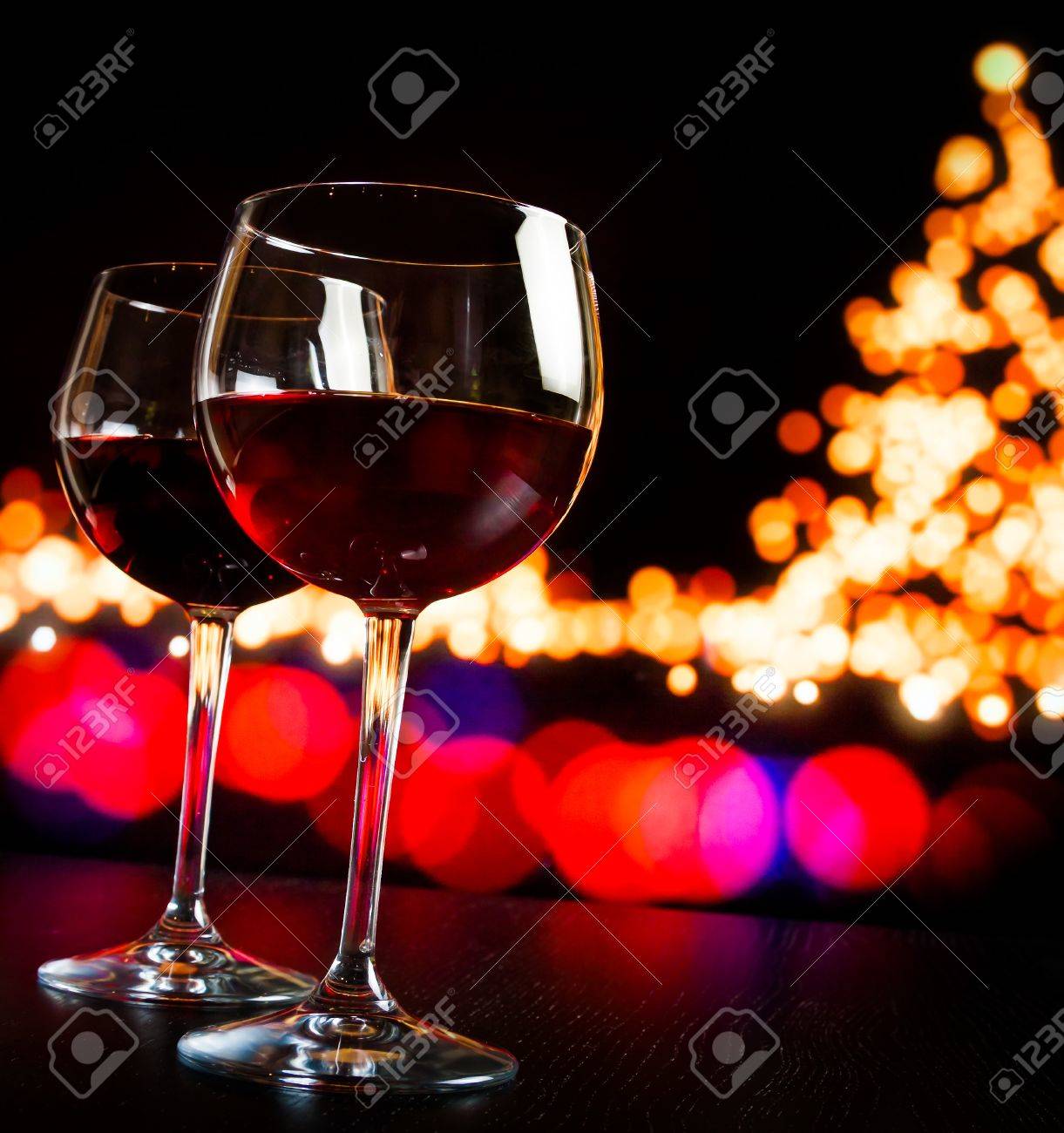 Two Red Wine Glass Against Bokeh Lights Tree Background Christmas