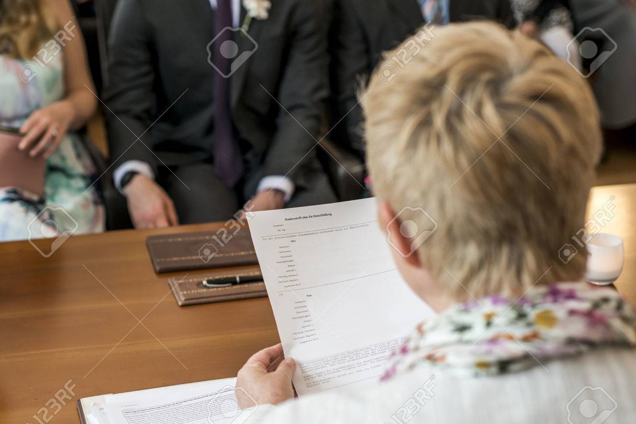 marriage registrar holding german wedding register reading bride