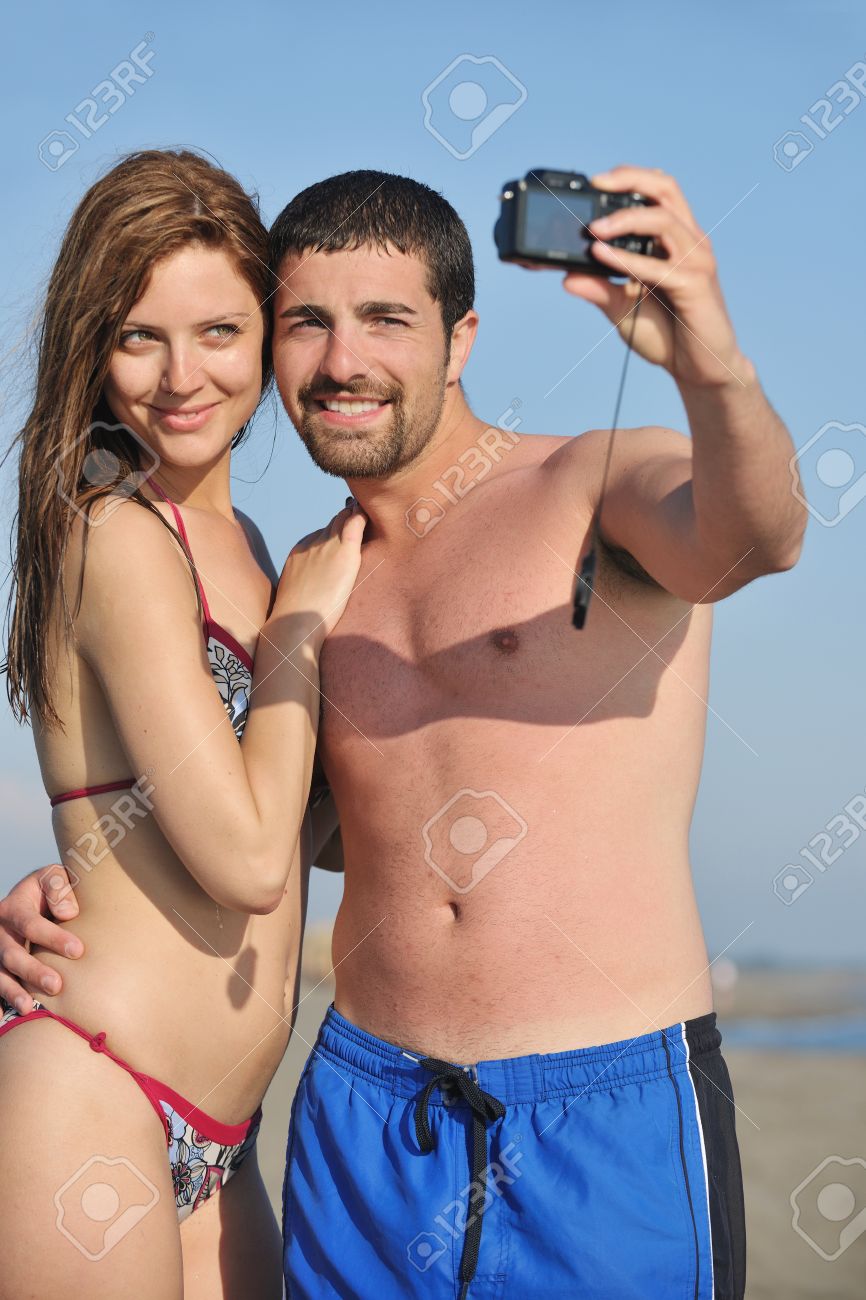 Happy Young Couple In Love Taking Amateur Self Portrait Photos On Beach Stock Photo, Picture and Royalty Free Image Adult Picture