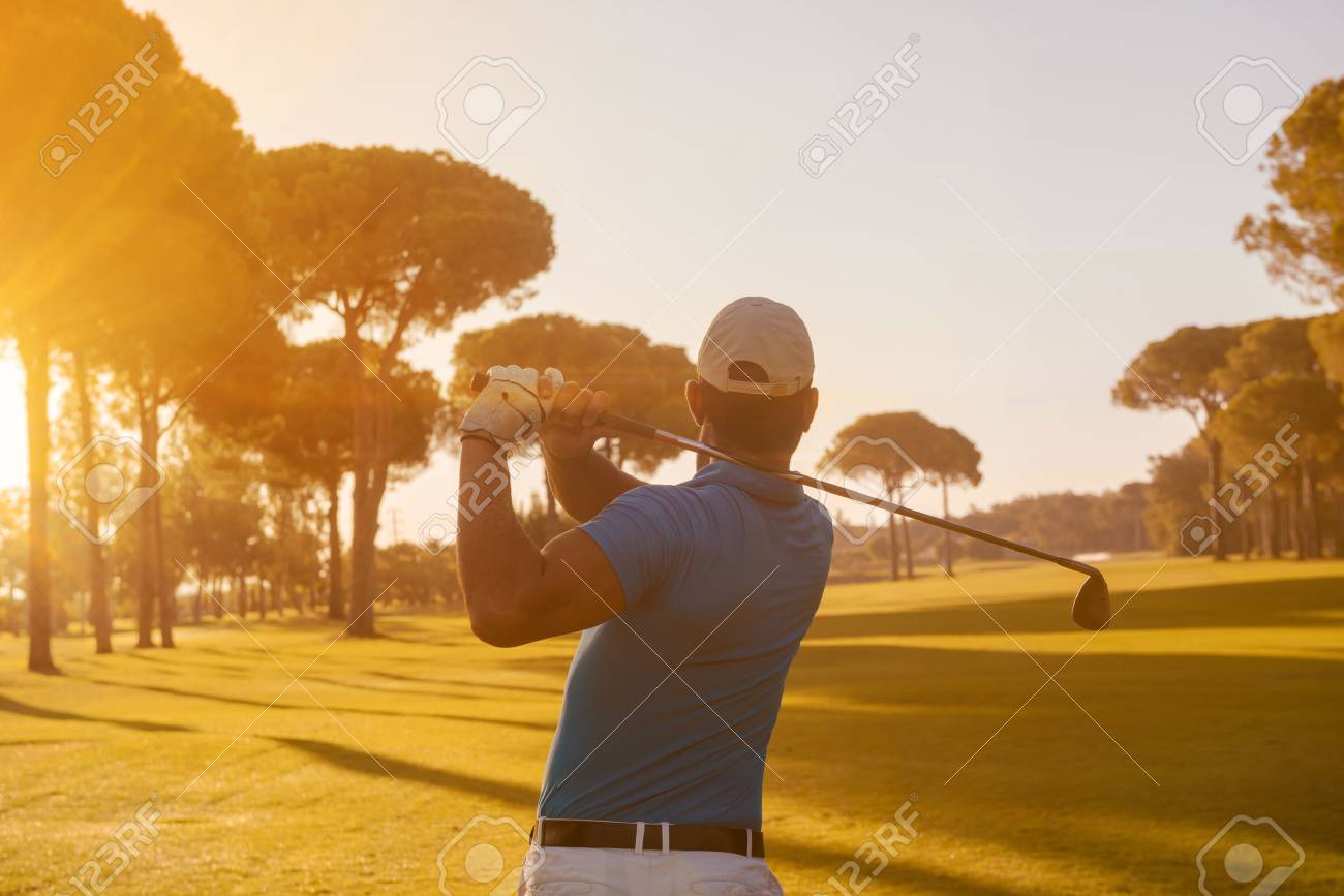golf player hitting shot with club on course at beautiful morning with sun flare in background - 67328077 golf player hitting shot with club on course at beautiful morning with sun flare in background - 67328077