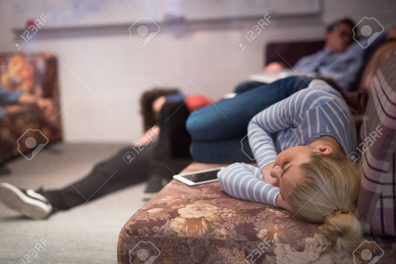 group of young casual software developer sleeping on sofa during