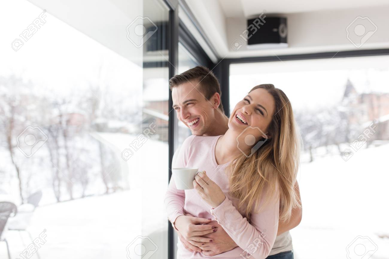 romantic happy young couple enjoying morning coffee by the window on cold winter day at home - 90863599 romantic happy young couple enjoying morning coffee by the window on cold winter day at home - 90863599