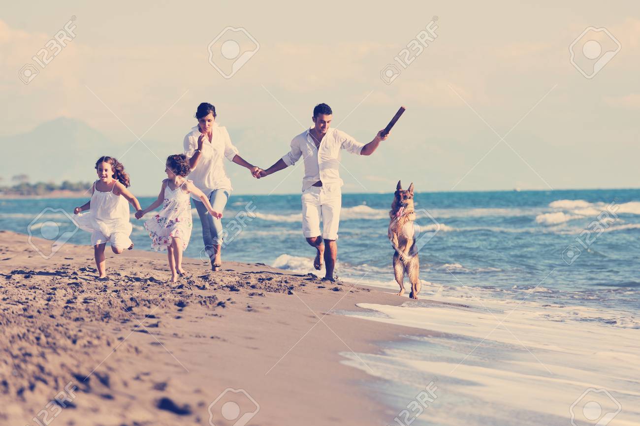 happy young family in white clothing have fun and play with beautiful dog at vacations on beautiful beach - 98432131 happy young family in white clothing have fun and play with beautiful dog at vacations on beautiful beach - 98432131