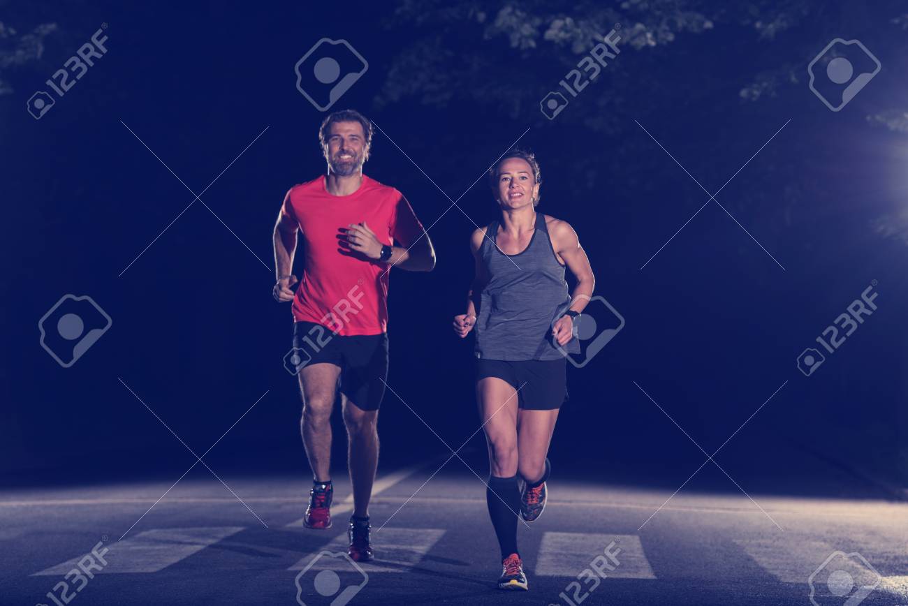group of healthy people jogging in city park, runners team at night training - 107002795 group of healthy people jogging in city park, runners team at night training - 107002795