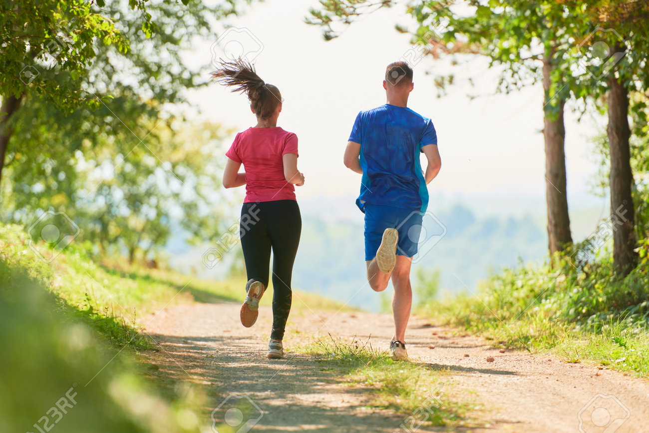 couple enjoying in a healthy lifestyle while jogging on a country road - 166294813 couple enjoying in a healthy lifestyle while jogging on a country road - 166294813