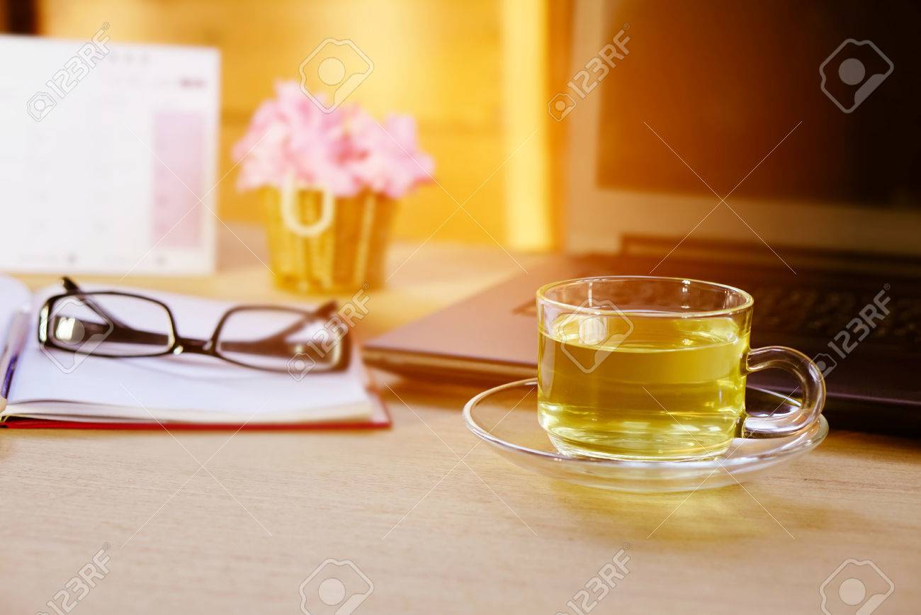 背景をぼかし 木製テーブルの上の紅茶のカップの絵ノートブック ノート パソコン フラワー ポット カレンダーは フォア グラウンドでは の写真素材 画像素材 Image