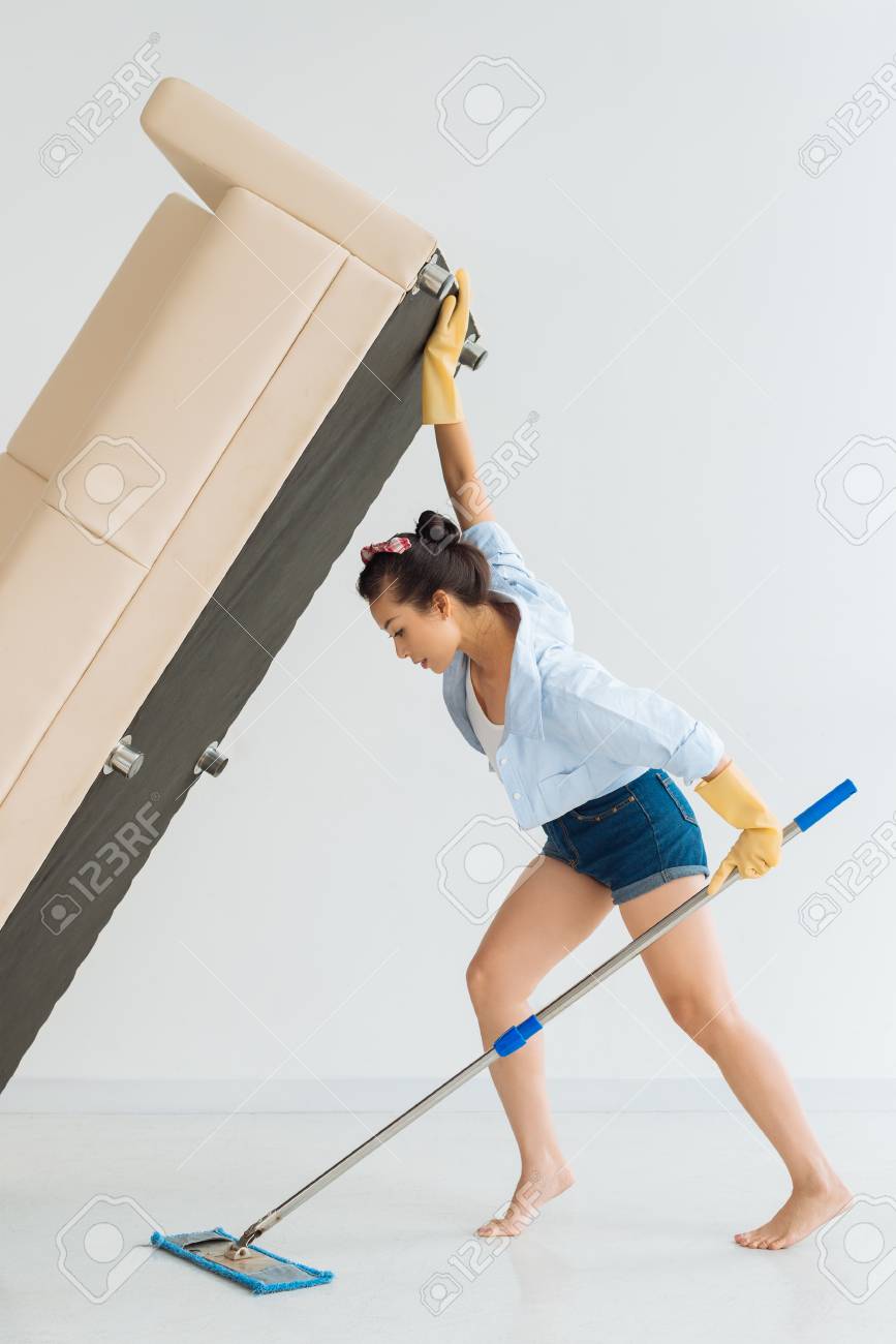 Housewife Lifting Sofa To Wipe