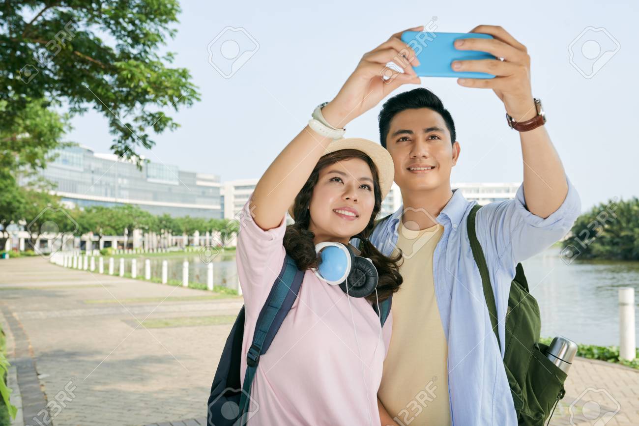 屋外 Selfie を撮るときに笑顔元気なベトナム人カップル の写真素材 画像素材 Image