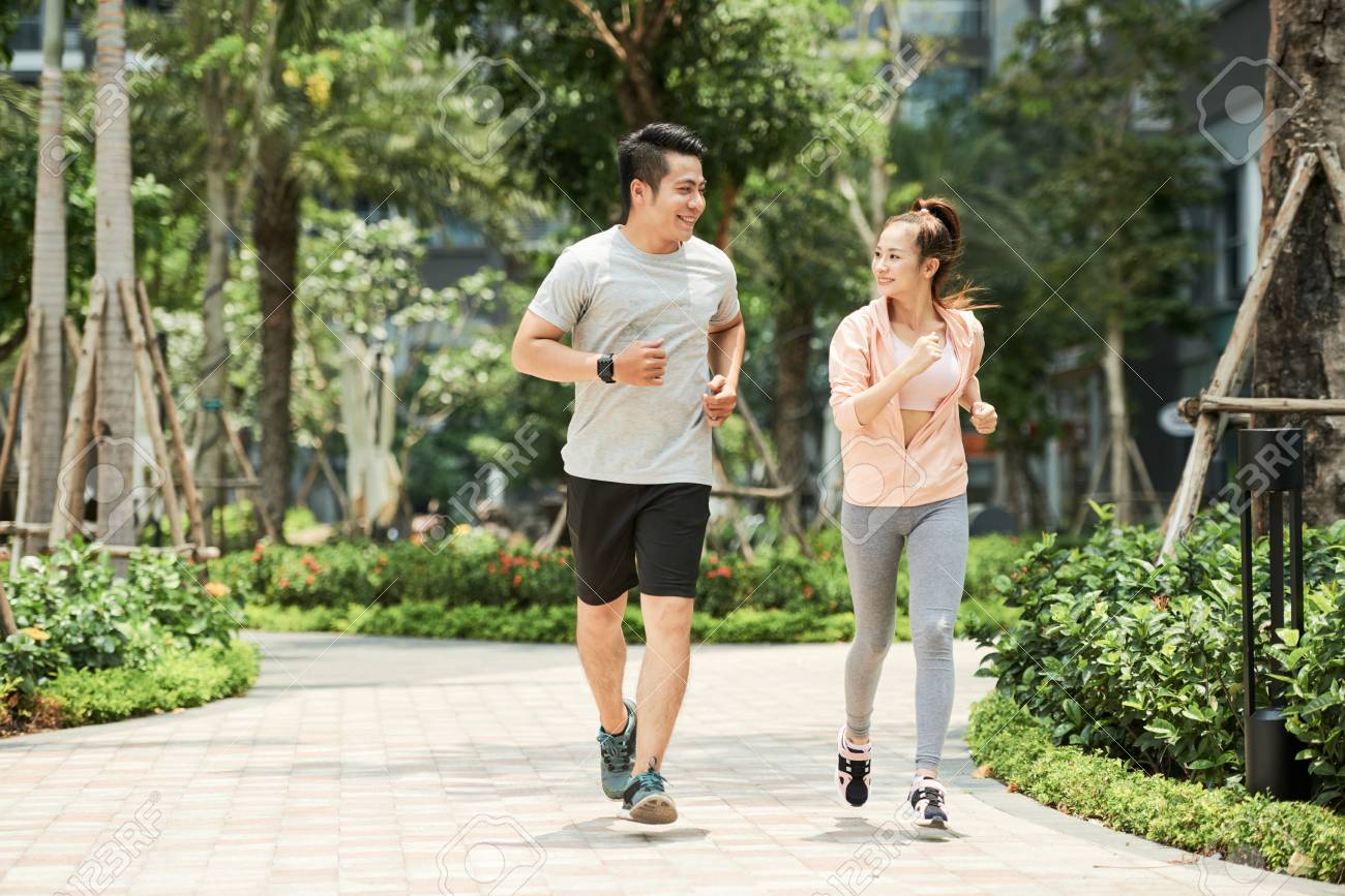 Vietnamese man and woman jogging together in the park - 102256731 Vietnamese man and woman jogging together in the park - 102256731