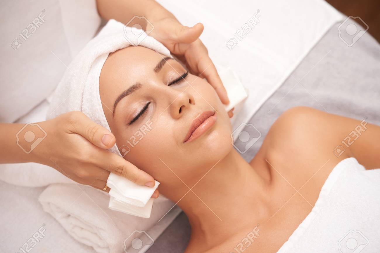 Beautiful young woman with flawless skin enjoying professional facial in beauty salon - 106088072 Beautiful young woman with flawless skin enjoying professional facial in beauty salon - 106088072