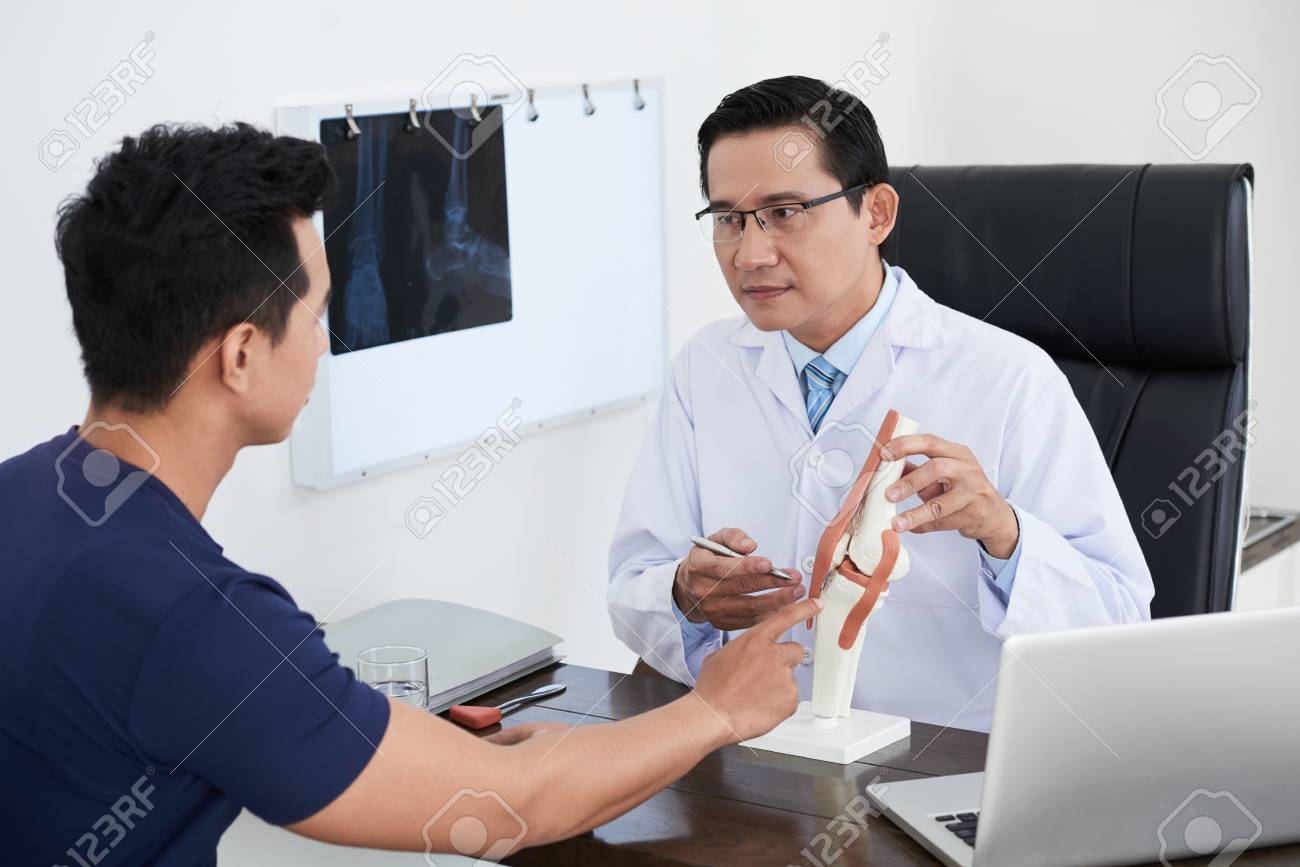 Doctor explaining structure of joint to patient - 106581333 Doctor explaining structure of joint to patient - 106581333