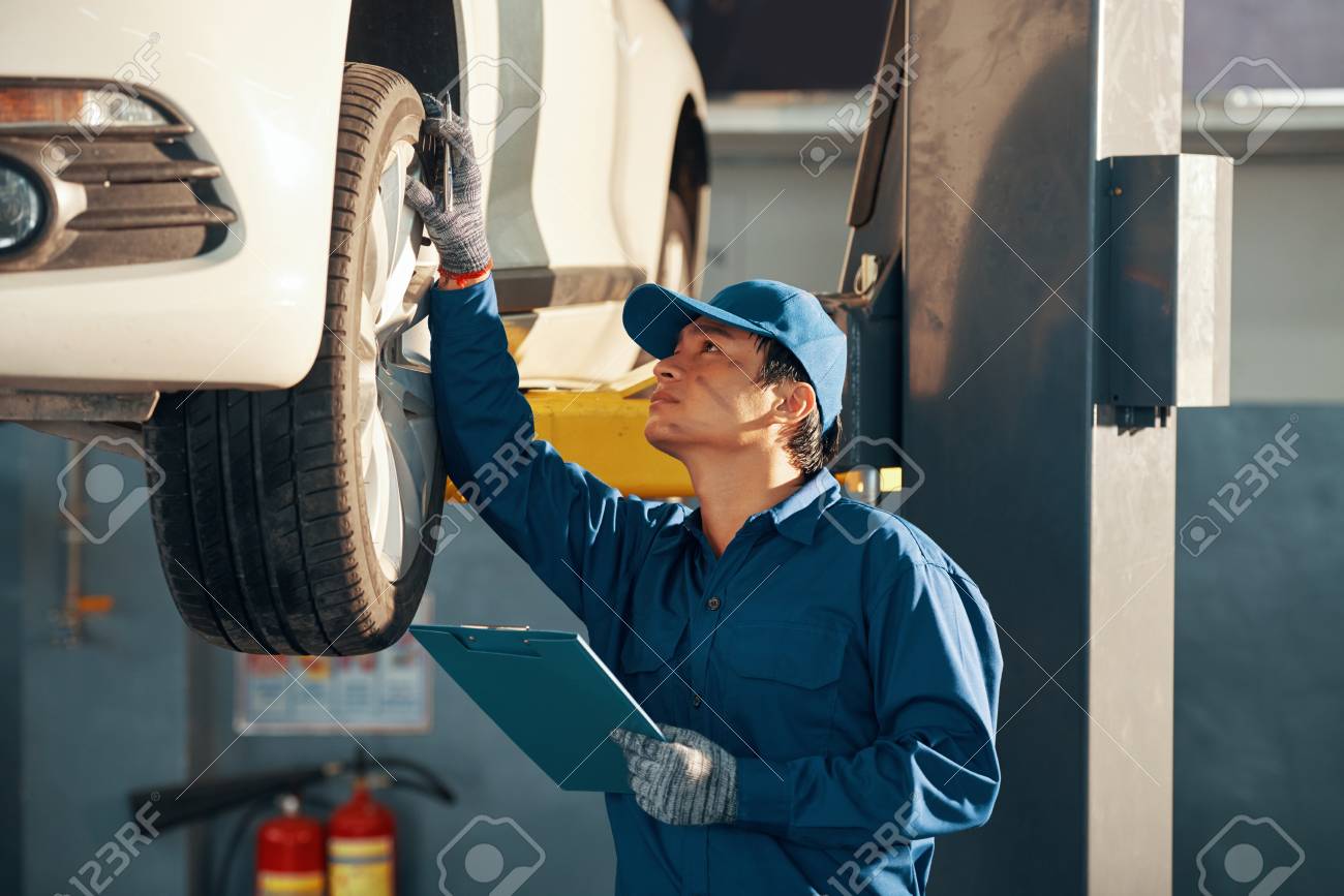 Mechanic checking car - 107064706 Mechanic checking car - 107064706