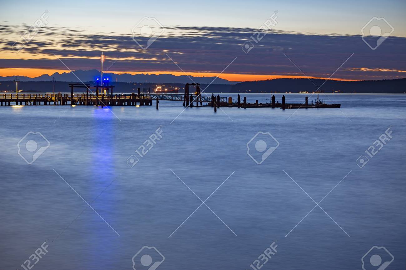 タコマはアメリカの国旗と夕暮れ時にドッキングします 夕暮れ時と日暮れにワシントン州タコマの湾 の写真素材 画像素材 Image