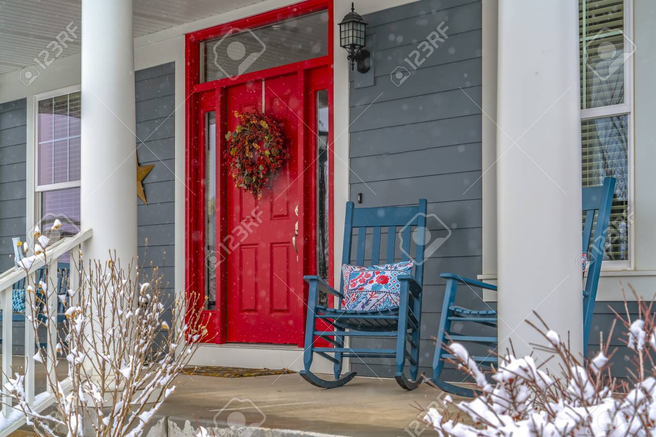 Winter View Of Home With Red Door And Front Porch A Wreath Hangs