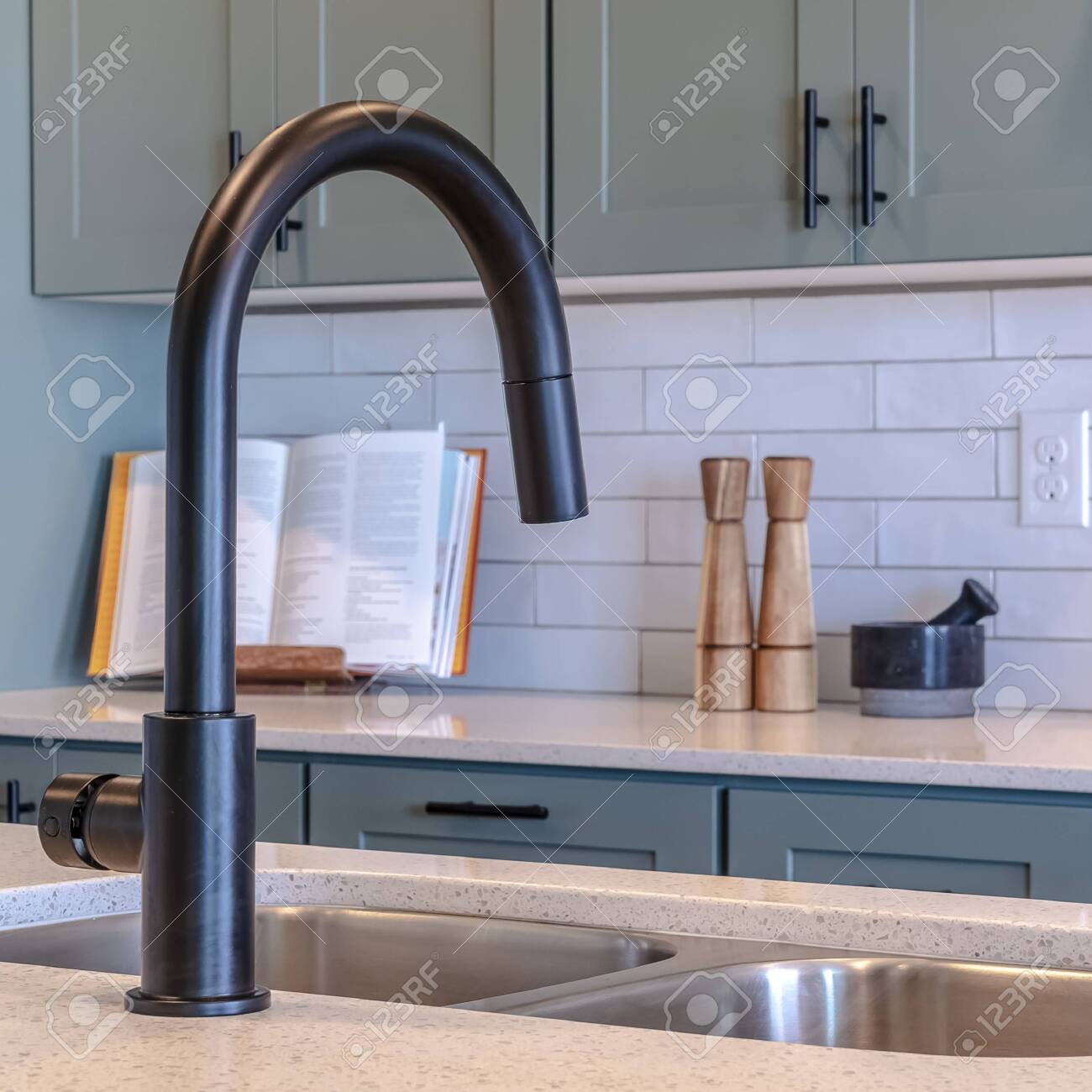 Square Frame Kitchen Island Sink And Black Faucet Against Cooktop Stock Photo Picture And Royalty Free Image Image 139157062