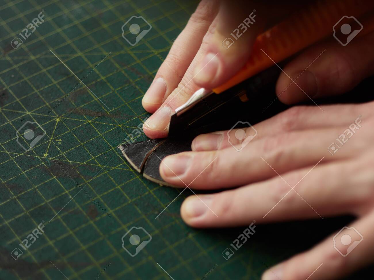 Shaping the tip of the leather strap with a knife. - 131722426 Shaping the tip of the leather strap with a knife. - 131722426