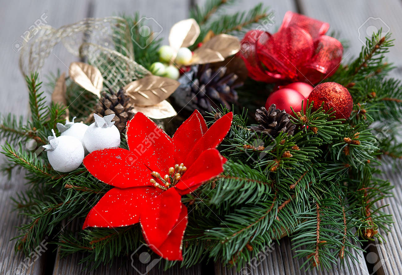 木の背景に赤いボール、ライト、松ぼっくりで飾られたクリスマスリース 