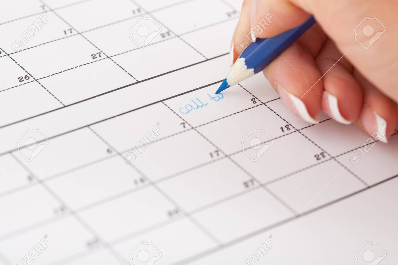 womans hand with pencil try to write reminder in calendar write in calendar