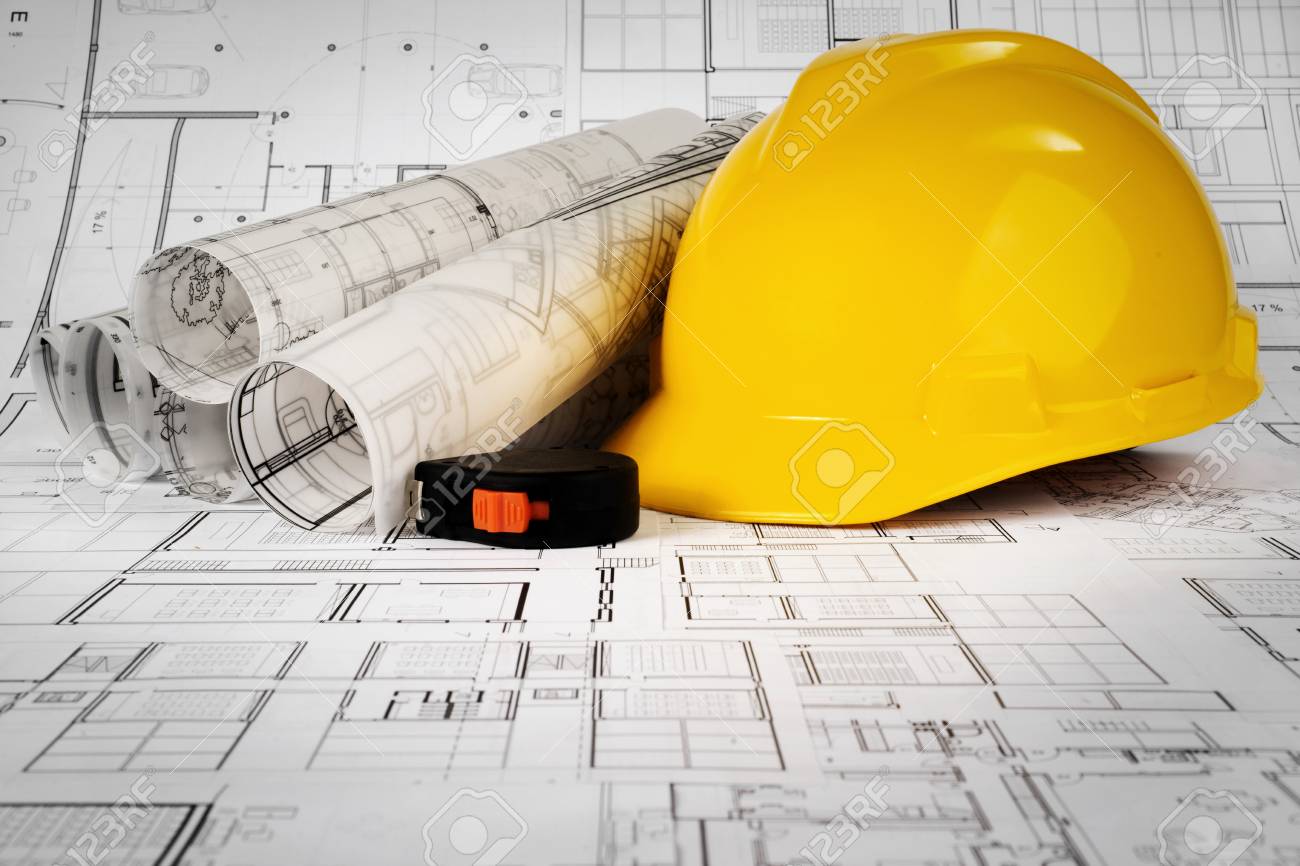 Yellow helmet, tape measure and project drawings - 99972369 Yellow helmet, tape measure and project drawings - 99972369