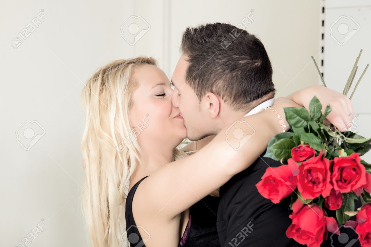 A Kiss Of Love Between A Man And A Woman Following A Romantic Proposal Of  Marriage Or To Celebrate A Gift Of Roses And Lifelong Commitment Stock  Photo, Picture And Royalty Free