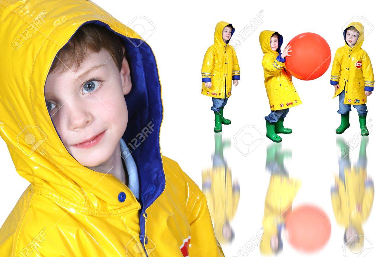 Cuatro años chico con grandes ojos azules en un chubasquero amarillo y verde rana botas Foto