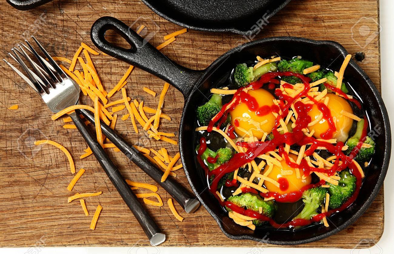 Uncooked Raw Eggs In Skillet With Brocolli Cheese And Sriracha