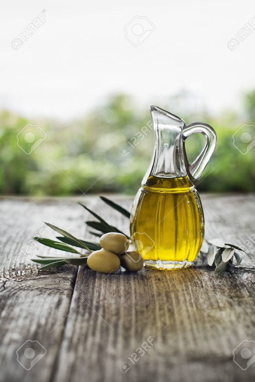 Olive oil and olive branch on the wooden table - 34200735 Olive oil and olive branch on the wooden table - 34200735