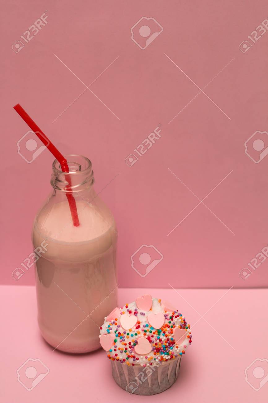 Milk Shake Aux Fraises Rose Dans Une Bouteille Avec Une Paille Cocktail Et Mignon Petit Gateau Sur Un Fond Rose Banque D Images Et Photos Libres De Droits Image