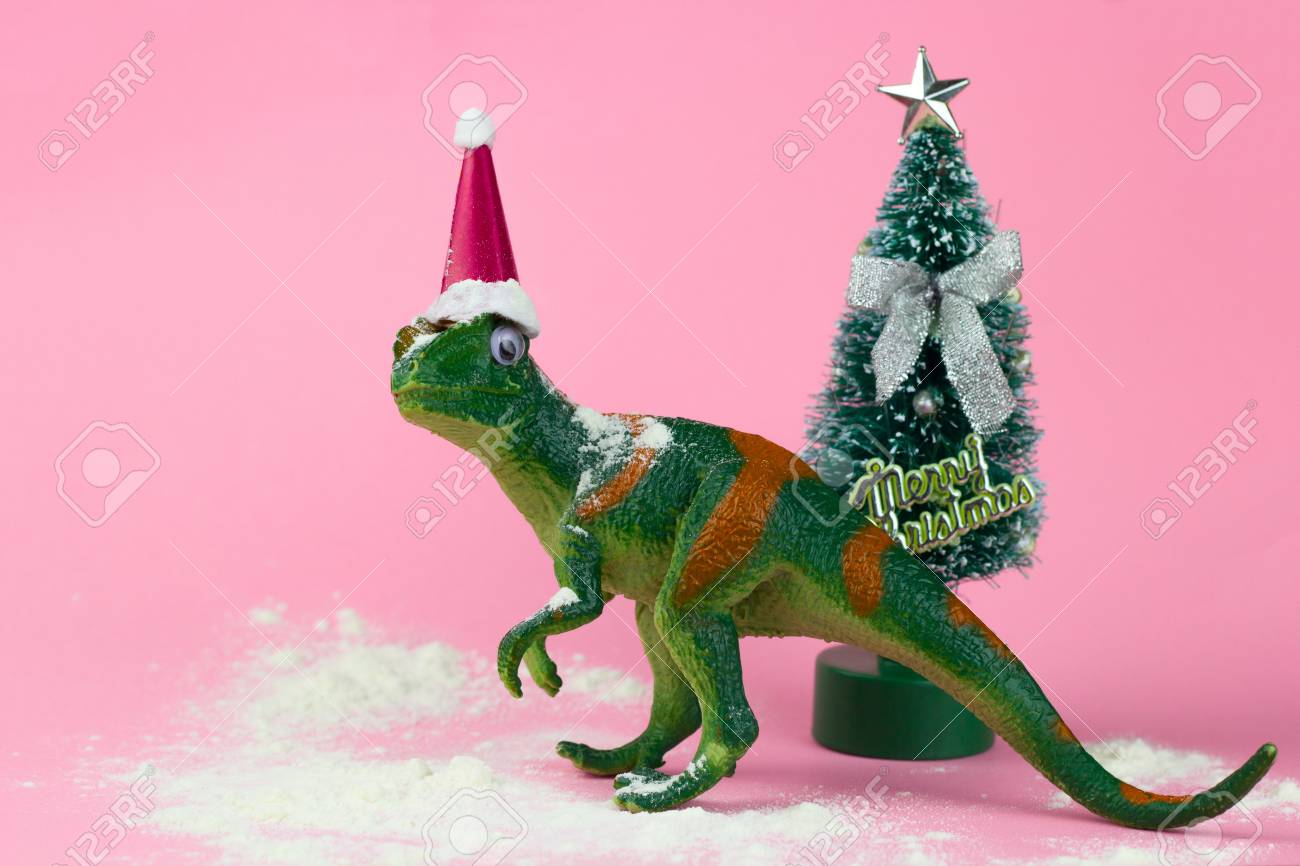 Funny Green Dinosaur Toy In Little Santa Claus Hat Near Little Christmas Tree On Pastel Pink Background Stock Photo, Picture And Royalty Free Image. Image 109244069. Funny Green Dinosaur Toy In Little Santa Claus Hat Near Little Christmas Tree On Pastel Pink Background Stock Photo, Picture And Royalty Free Image. Image 109244069.